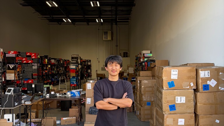 ShipNinja team member standing in the Somerset warehouse surrounded by inventory and shipping boxes