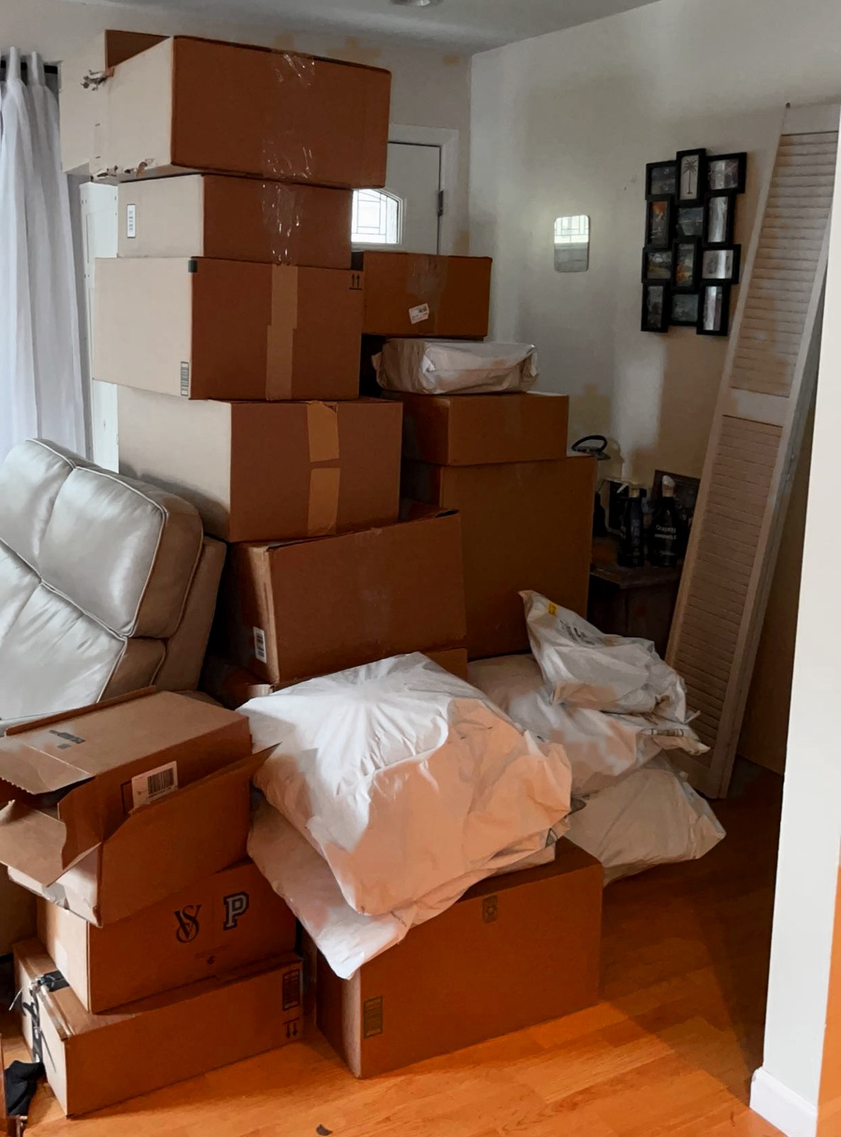 Shipping boxes and poly mailers stacked floor to ceiling in the ShipNinja founder's living room before the warehouse.